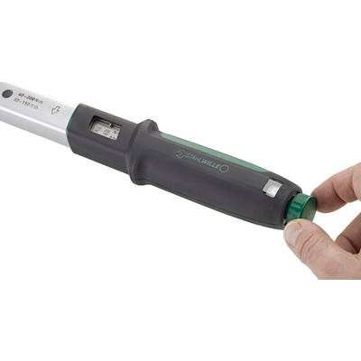 A torque wrench is tightening a nut on a shiny black car wheel rim to ensure proper fastening.