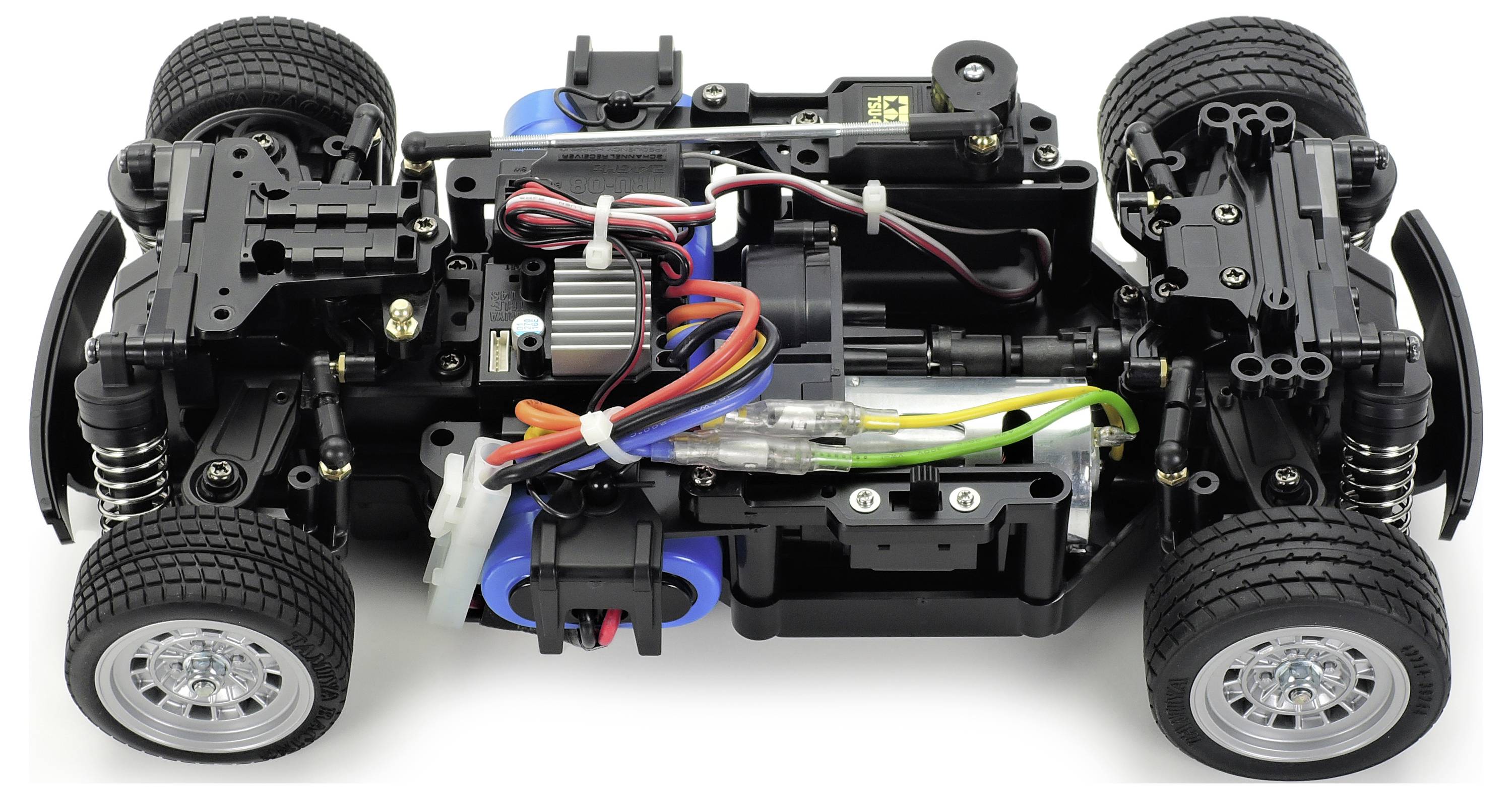 Remote-controlled car chassis in close-up. Motor, cables, suspension, and wheels are visible, without the bodywork.