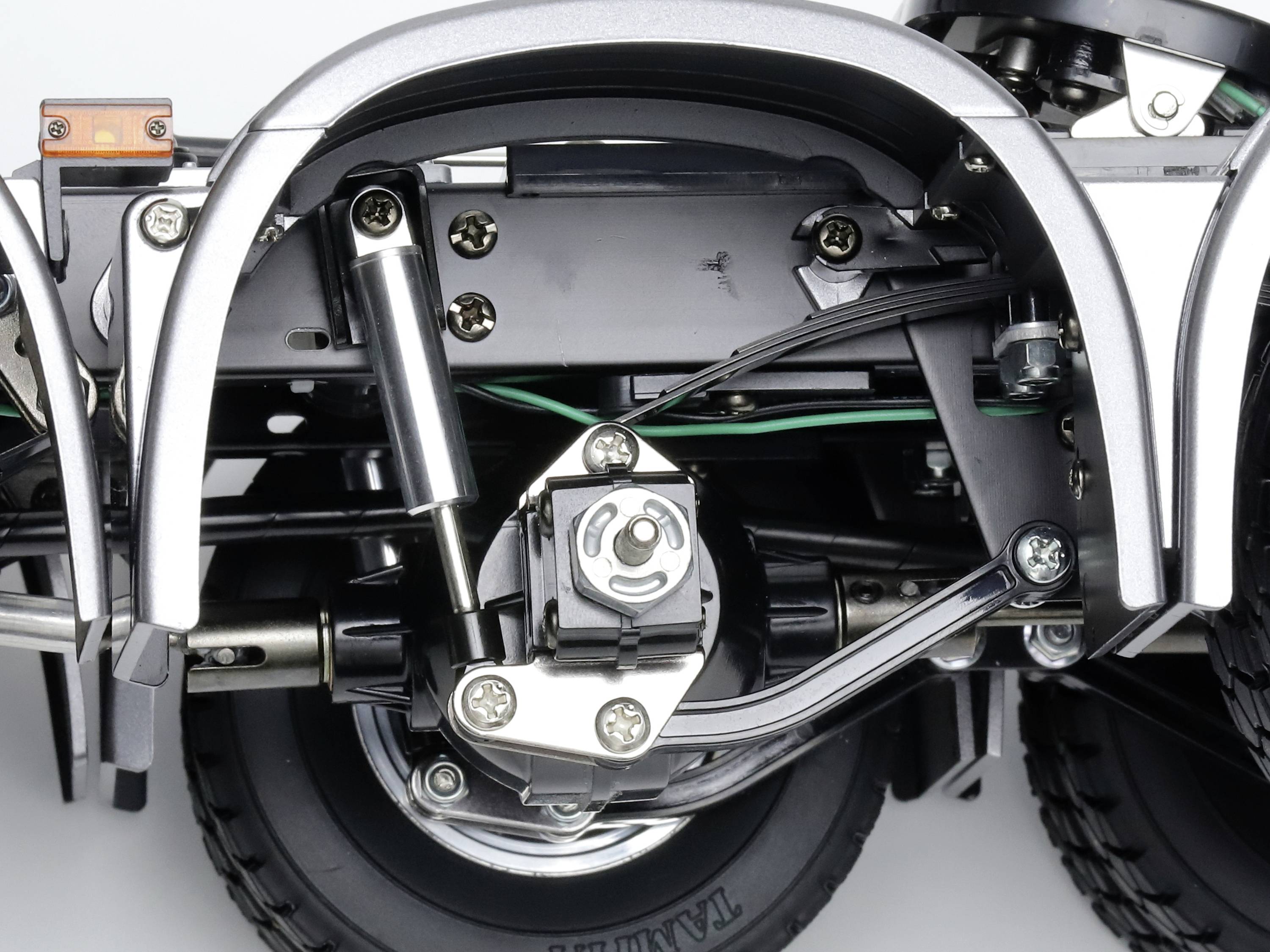 Close-up of a complex vehicle suspension system with multiple visible springs, shock absorbers, and axles revealing structural details.