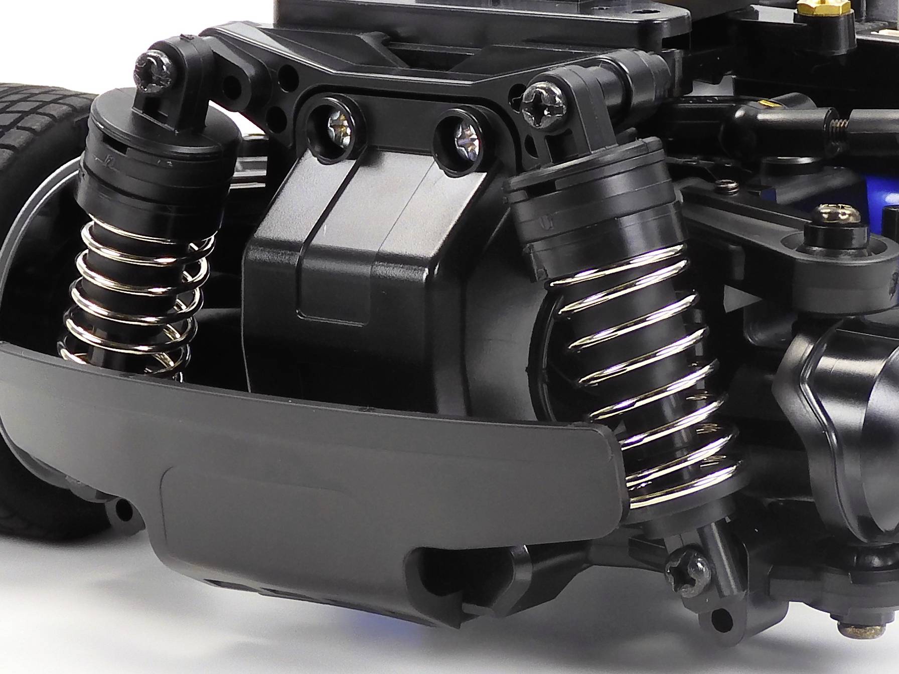 Close-up of the suspension and shock absorbers of a remote-controlled car, showing technical details and design elements.