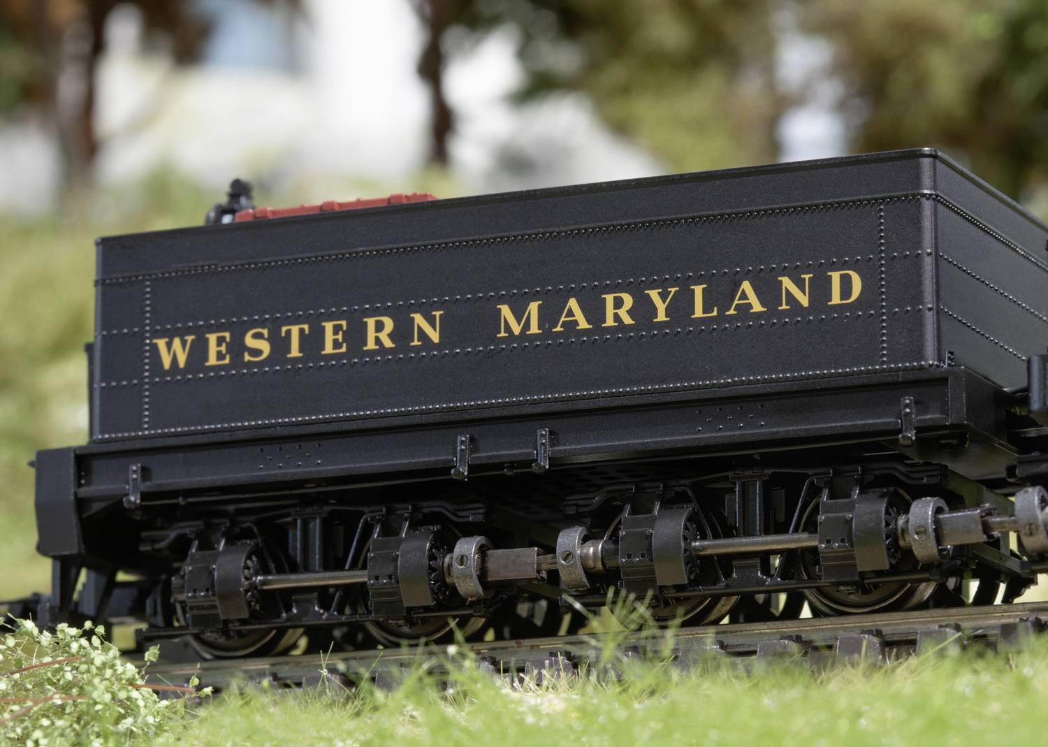 A black railway carriage with the inscription 'Western Maryland' is standing on a track. Trees are visible in the background.