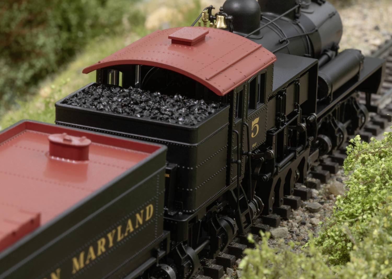 Historical steam locomotive with coal wagon, operated by the Maryland and Pennsylvania Railroad, travelling on a model railway layout.