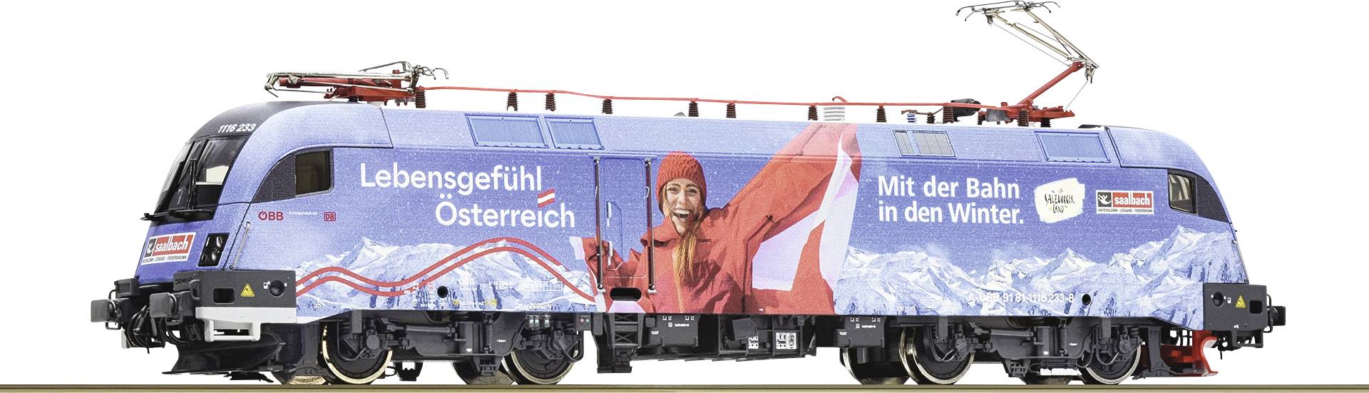 Blue locomotive with advertising for winter tourism in Austria, showing a smiling person in red winter clothing in front of mountains.