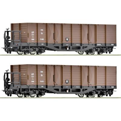 Two brown goods wagons on railway tracks, identical in design, with labelling on the side. Suitable for bulk cargo transport.