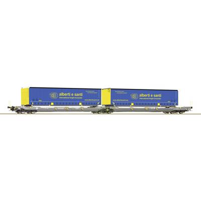 Two blue containers with yellow lettering 'albert o scani', loaded on a goods wagon. The scene depicts international freight transport.