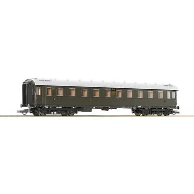 A dark green, historic railway passenger carriage with multiple windows. The carriage is standing on tracks and has a white roof.