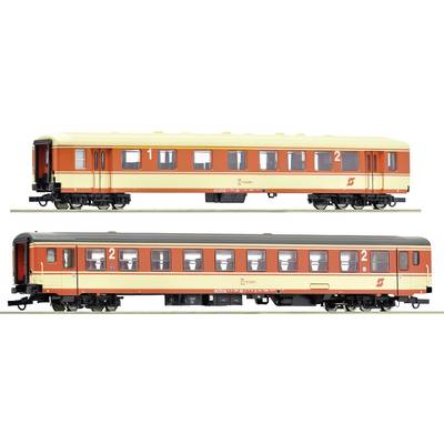 Two model railway carriages in red and beige. The upper one has a cream-coloured roof, the lower one a grey roof. Both display the number '2'.