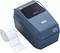 A navy blue label printer with an opening button, positioned next to a roll of white labels.