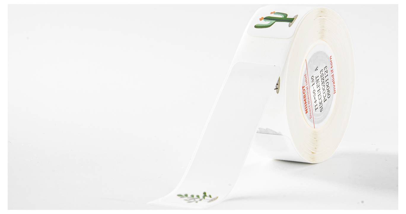 A white roll with stickers depicting a green cactus with a red flower. The cactus is printed on a white background.