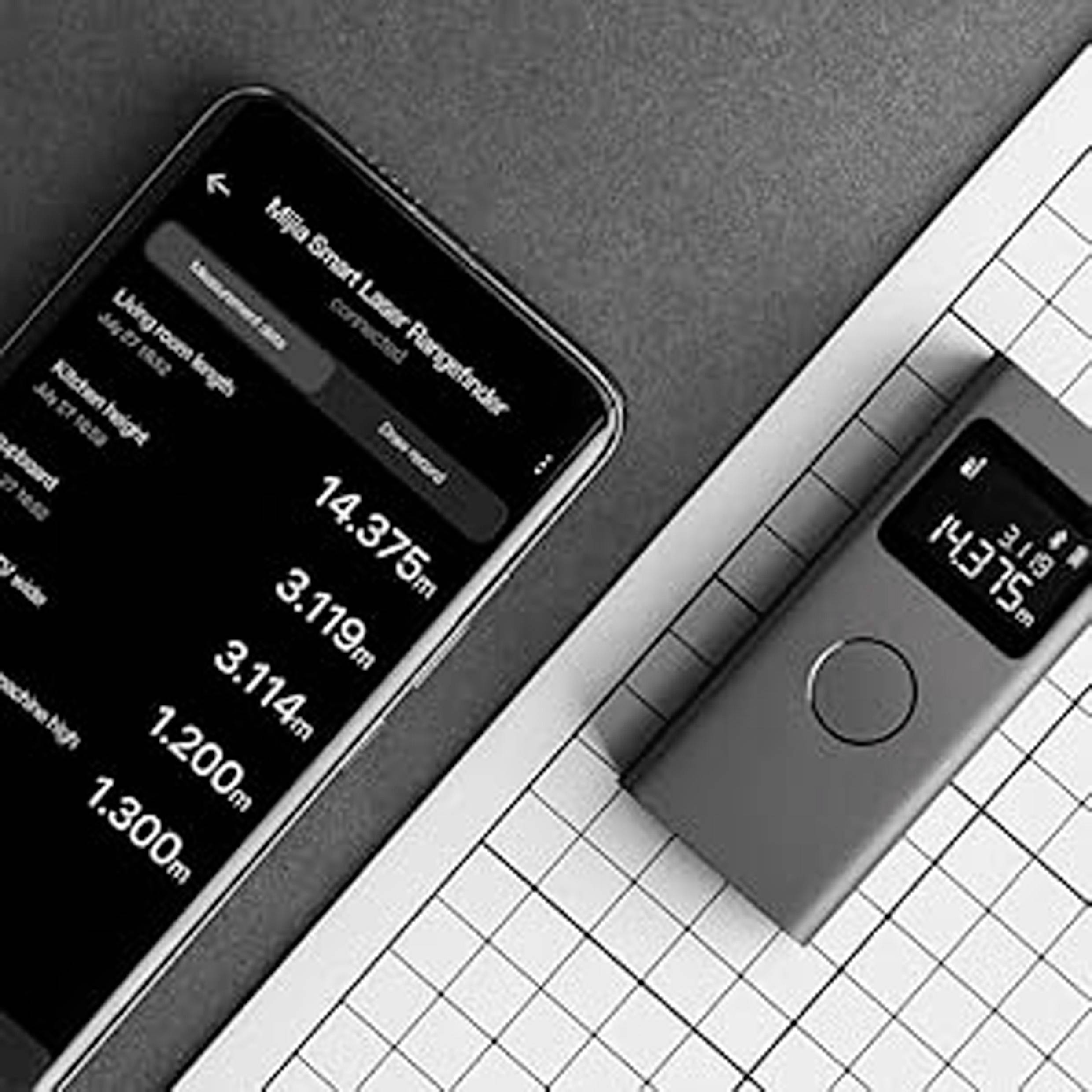 A smartphone displays an app with laser measurement data next to a handheld laser device showing measurements on its screen.