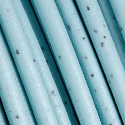 Several adjacent blue-colored drinking straws with black dots that show a pattern formation on the surface.