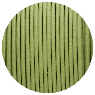 Close-up of a circular image of ordered, vertical, green lines on a textured surface.