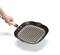 A hand is holding a square griddle pan with a wooden handle, featuring grooves for grill lines. It is black and made of metal.