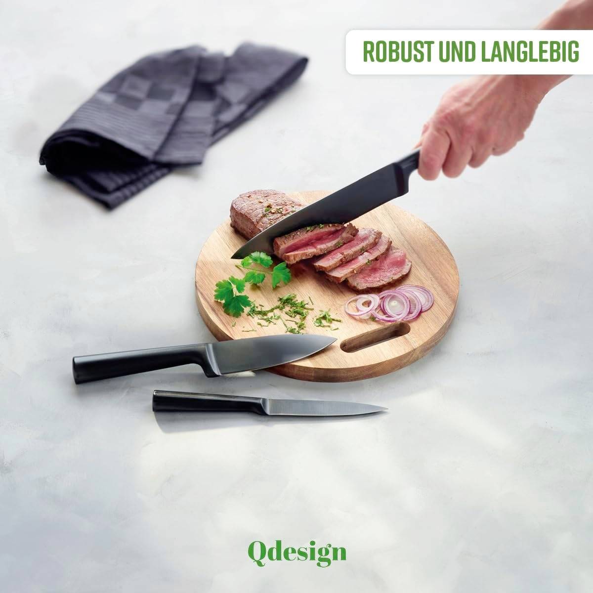 Hands cutting meat on a wooden board with a black knife. Two additional knives and onion rings beside it. Text: Robust and long-lasting.