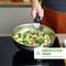 A person is holding a pot with vegetables, including broccoli and mushrooms. Text on the image: 'Can carry up to 10 kg. Ergonomic, sturdy handle'.