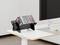'A modern office desk with a monitor and keyboard. A black rack holds several CDs, adding a touch of retro style to the workspace.'