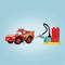A red toy car with the number 95 and flame design is shown next to a colorful Lego gas station.