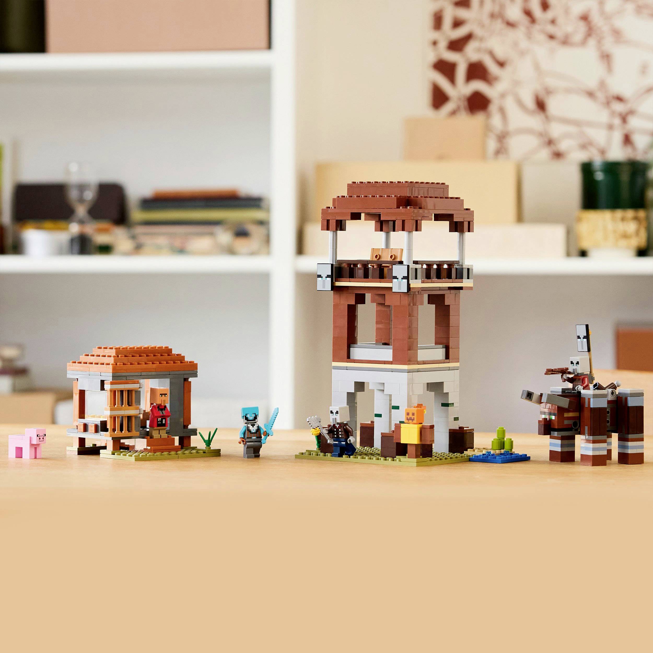 Toy building block set shows buildable village with tower, house, animals and figures. Background shows shelves with decorations.