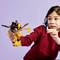 A child in a red sweater is playing with a colorful toy robot. The robot has movable parts and bright colors.