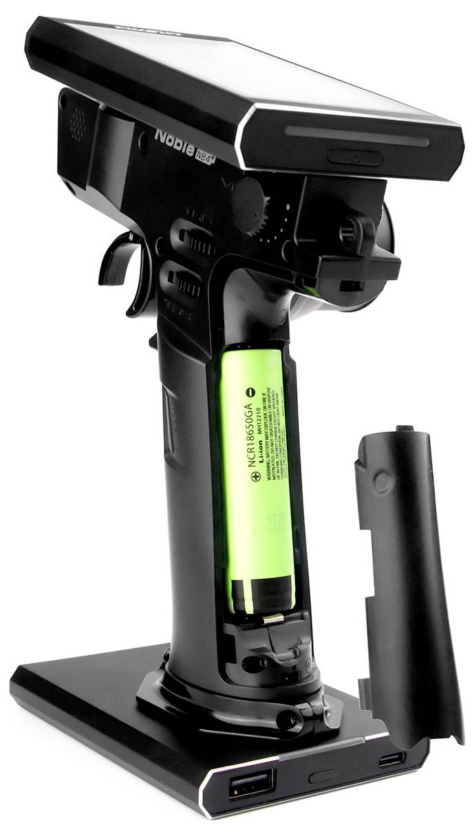 Hand scanner with an open battery compartment, showing a green, removable battery. Scanner on a black base with two USB ports.