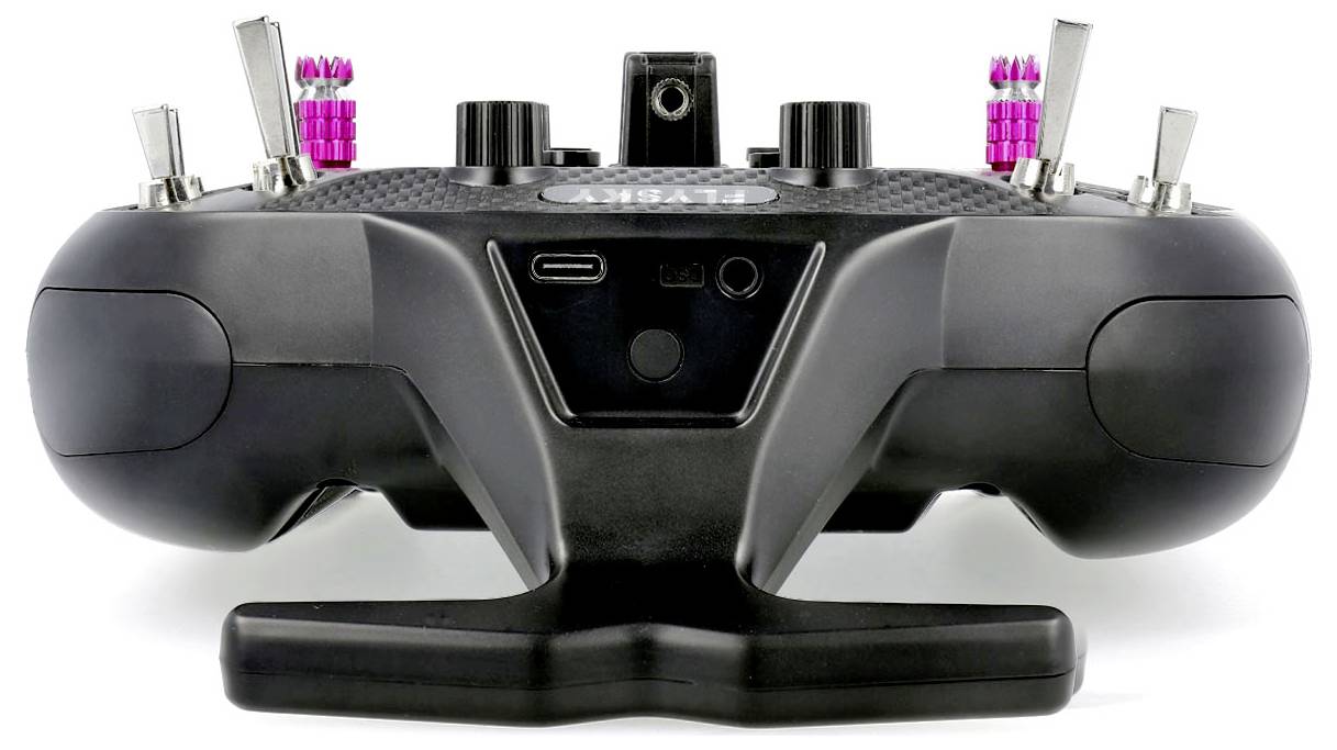 A black remote control with multiple toggle switches and pink buttons, presumably for control purposes, is shown from behind.