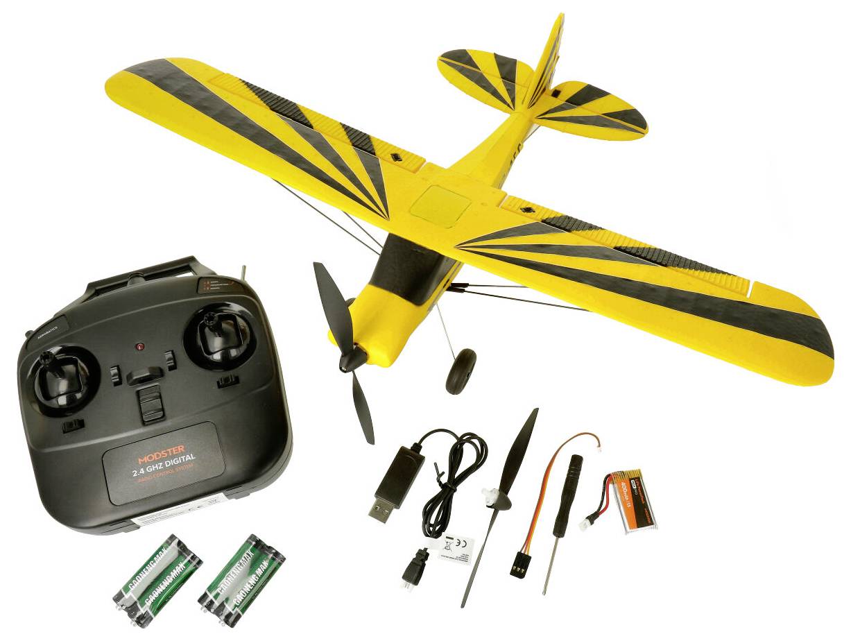Yellow model aircraft with a black striped pattern, alongside a remote control, batteries, charger, and small toolkit.