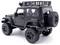 Black RC off-road model car with large tyres and roof rack, side rear view.