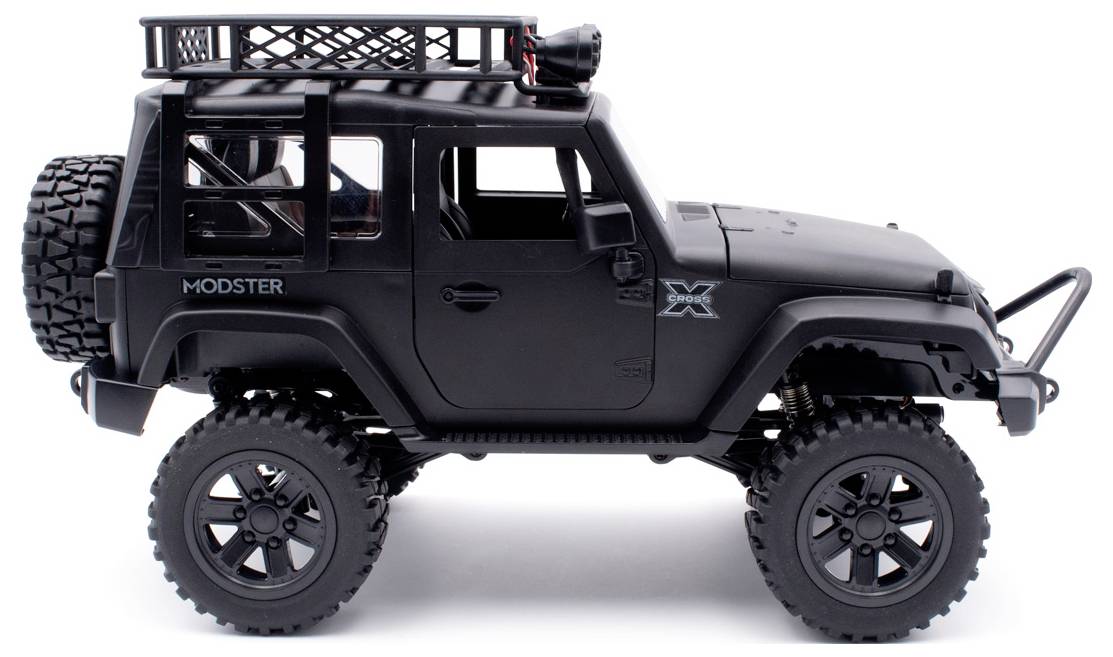 A black toy off-road vehicle with large tyres and a roof rack, photographed from the side.