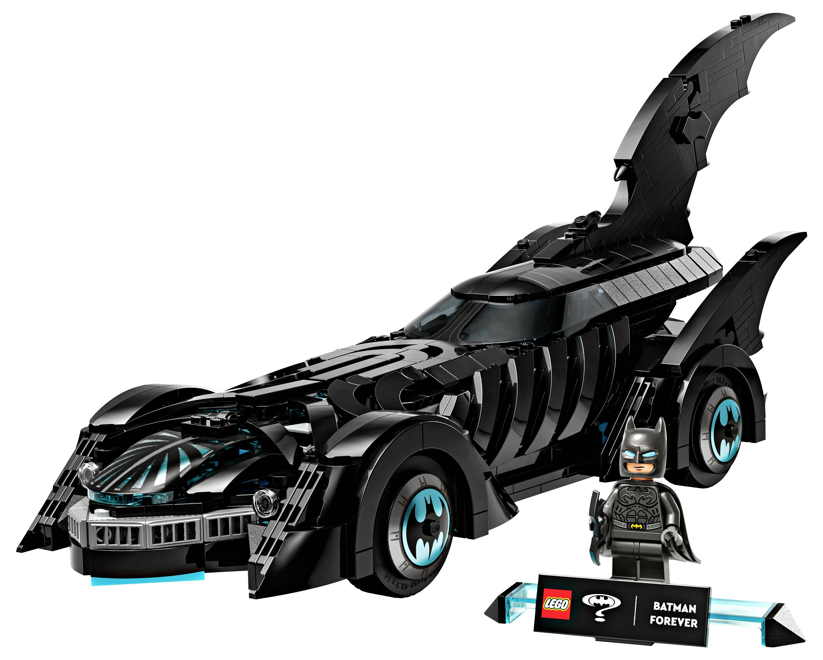 A Lego Batmobile with a Batman figurine next to it. The car is black with elements resembling a bat, and there's a small display sign reading 'Batman Forever'.