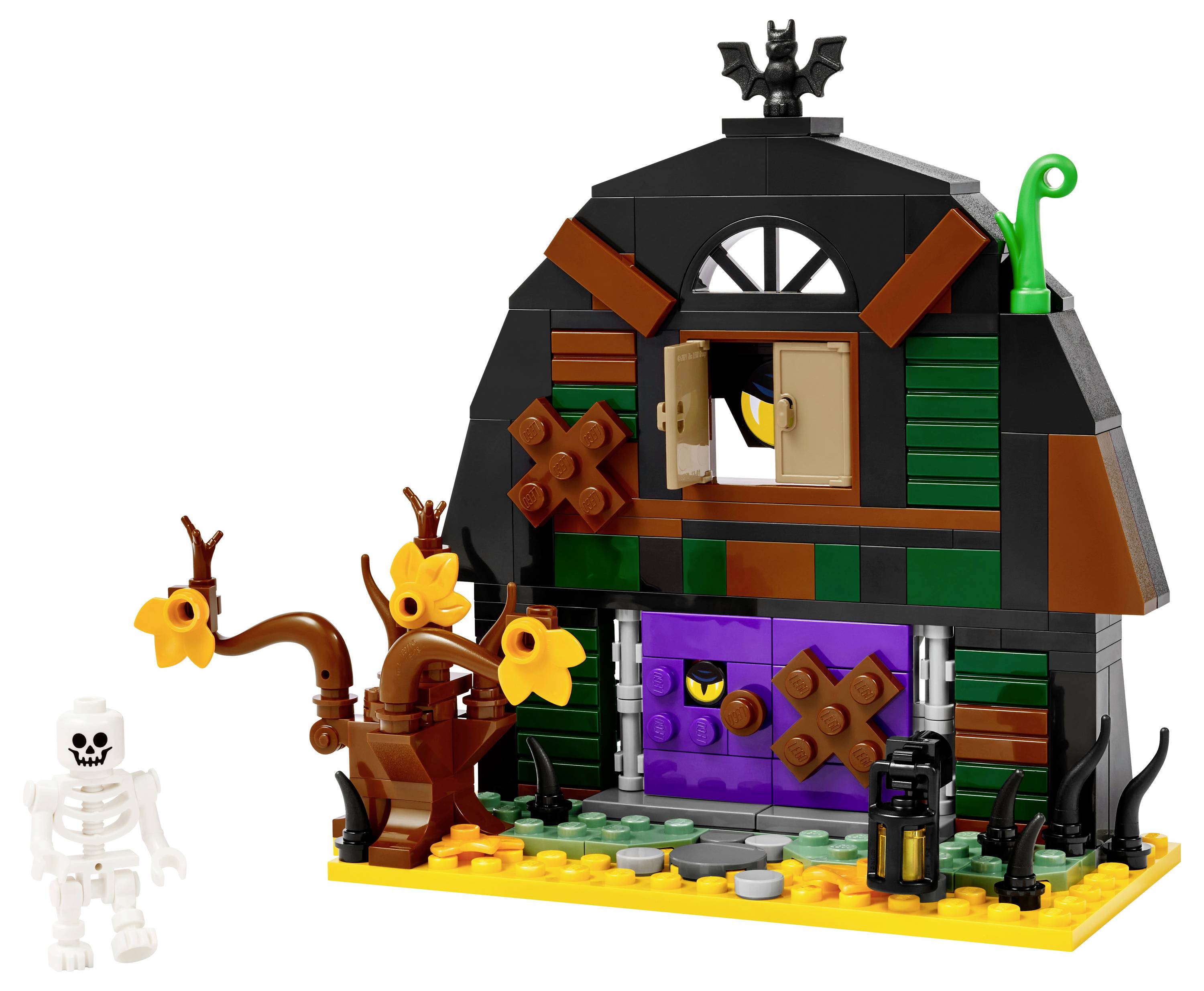 A LEGO Halloween-themed set features a spooky house with a bat on top, a skeleton figure, and twisted trees with orange flowers.