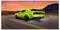A vibrant green toy car on a road, set against a dramatic sunset with mountains in the background, evokes speed and adventure.