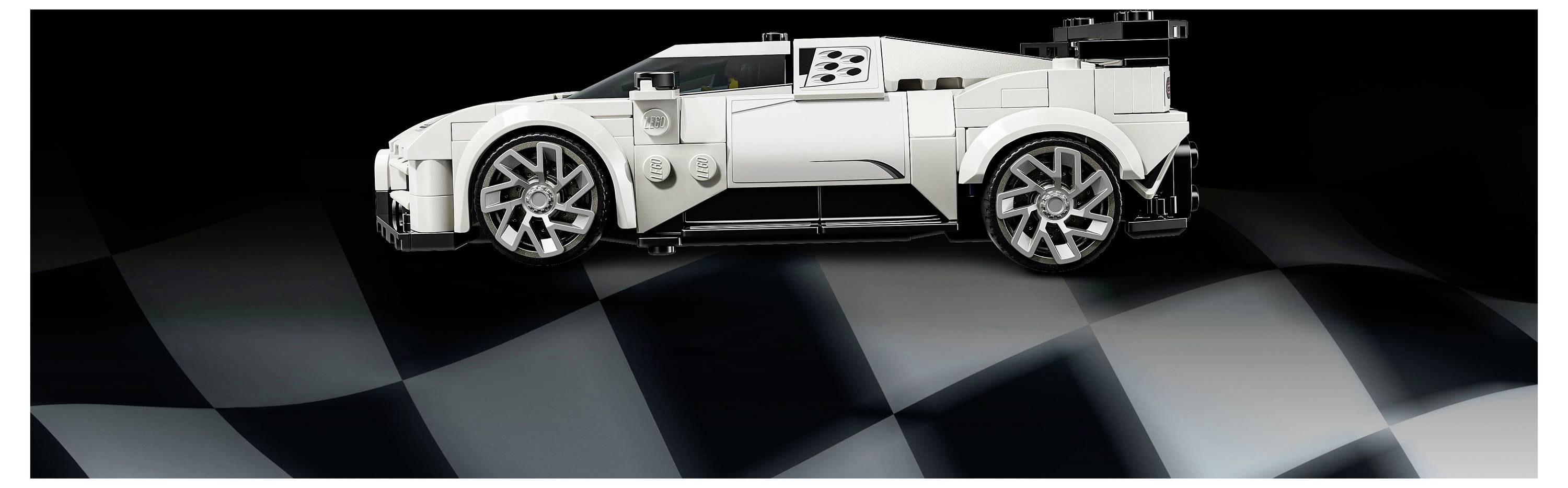 A detailed model of a white sports car is placed on a checkered surface, evoking a racing track atmosphere.