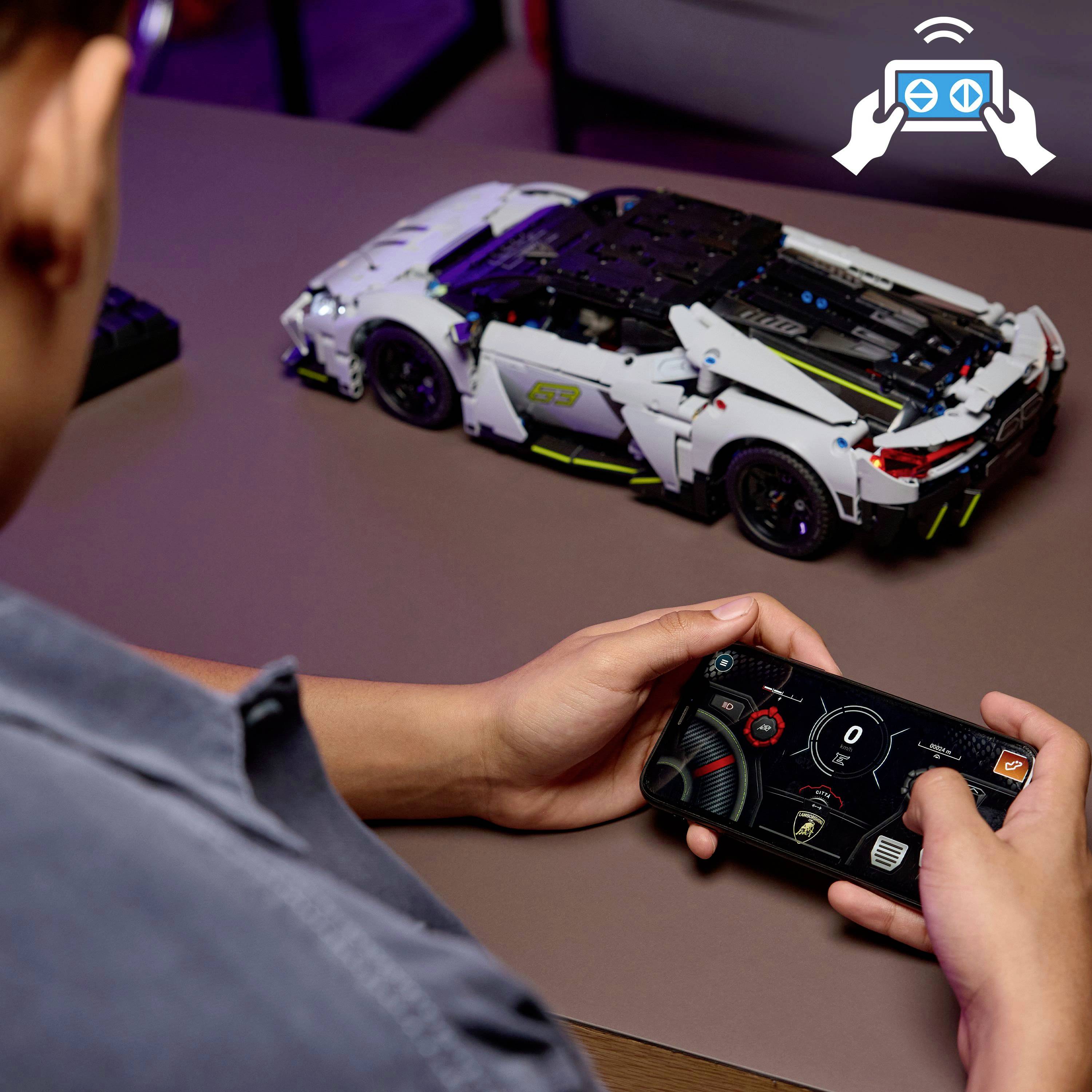 A person holds a smartphone with a remote control app to operate a Lego sports car model on a table, showcasing interactive play.