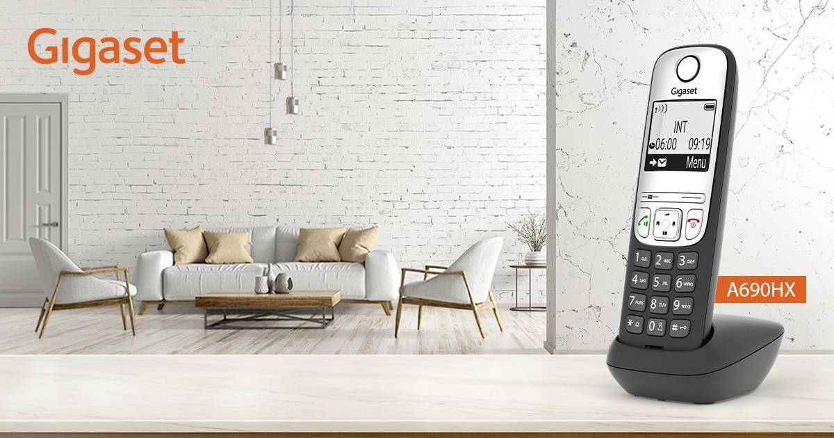 Cordless Gigaset A690HX telephone positioned in a modern living room, set against a white brick wall and beige sofa.