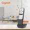 A cordless Gigaset A690HX telephone sits on a table in a modern living room with a grey sofa and pendant lights.