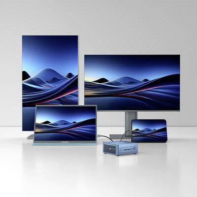 Several screens and a mini PC on a table, all displaying the same blue wave image on their displays.