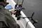 A person is sitting in a boat and using a smartphone mounted in a holder to navigate or fish on a lake.