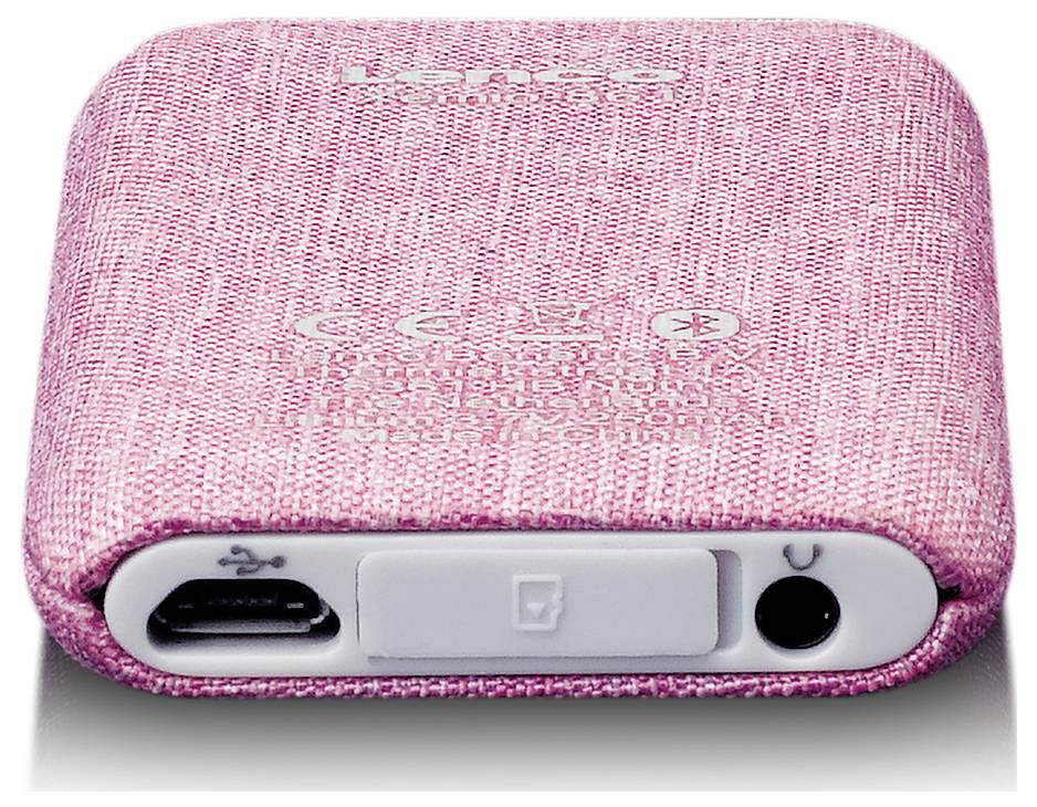 A pink, fabric-covered portable speaker with a charging port, USB port, and volume control.