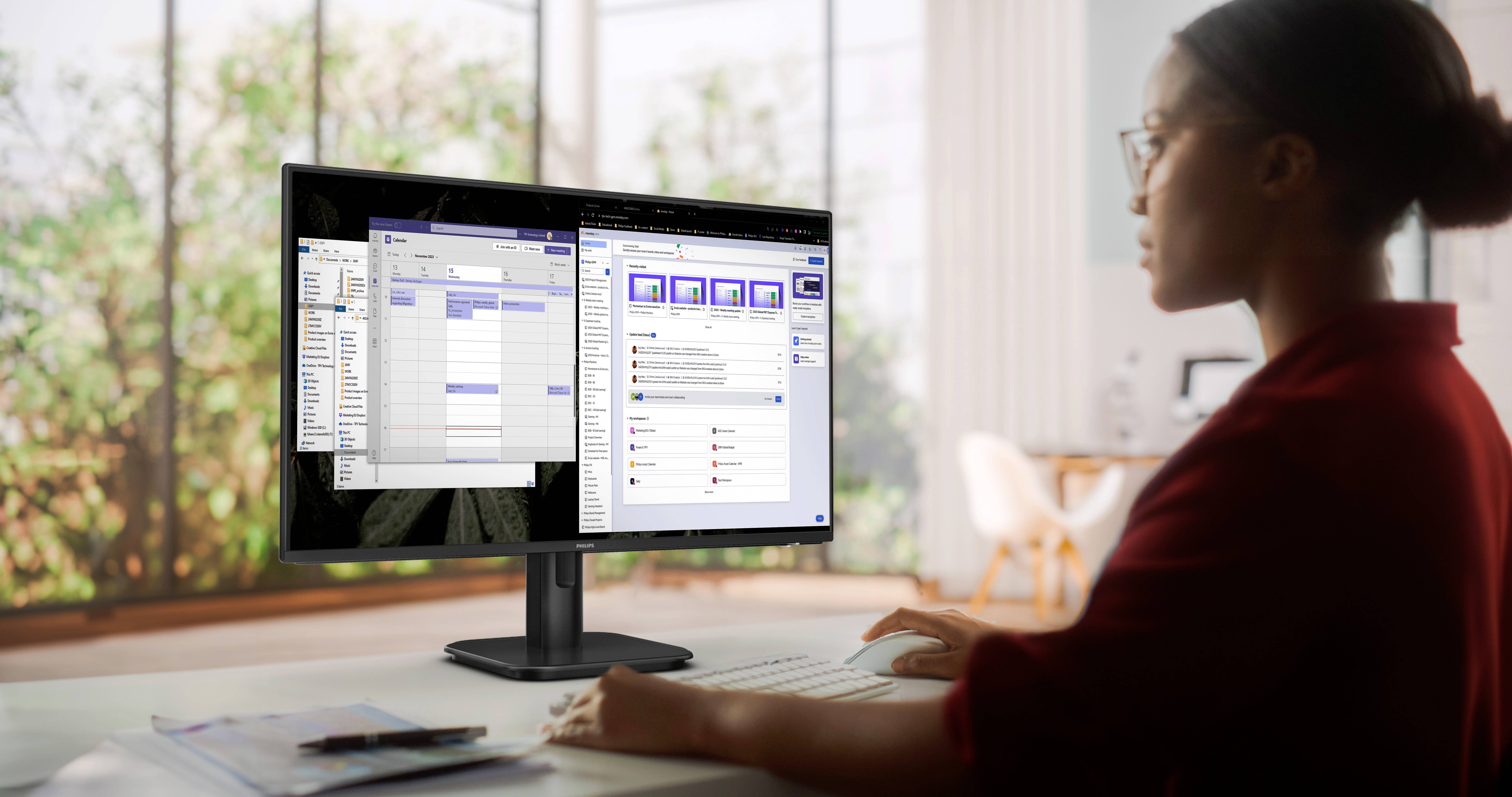 A person is working on a computer with two monitors. Calendar and communication apps are open on the screens.