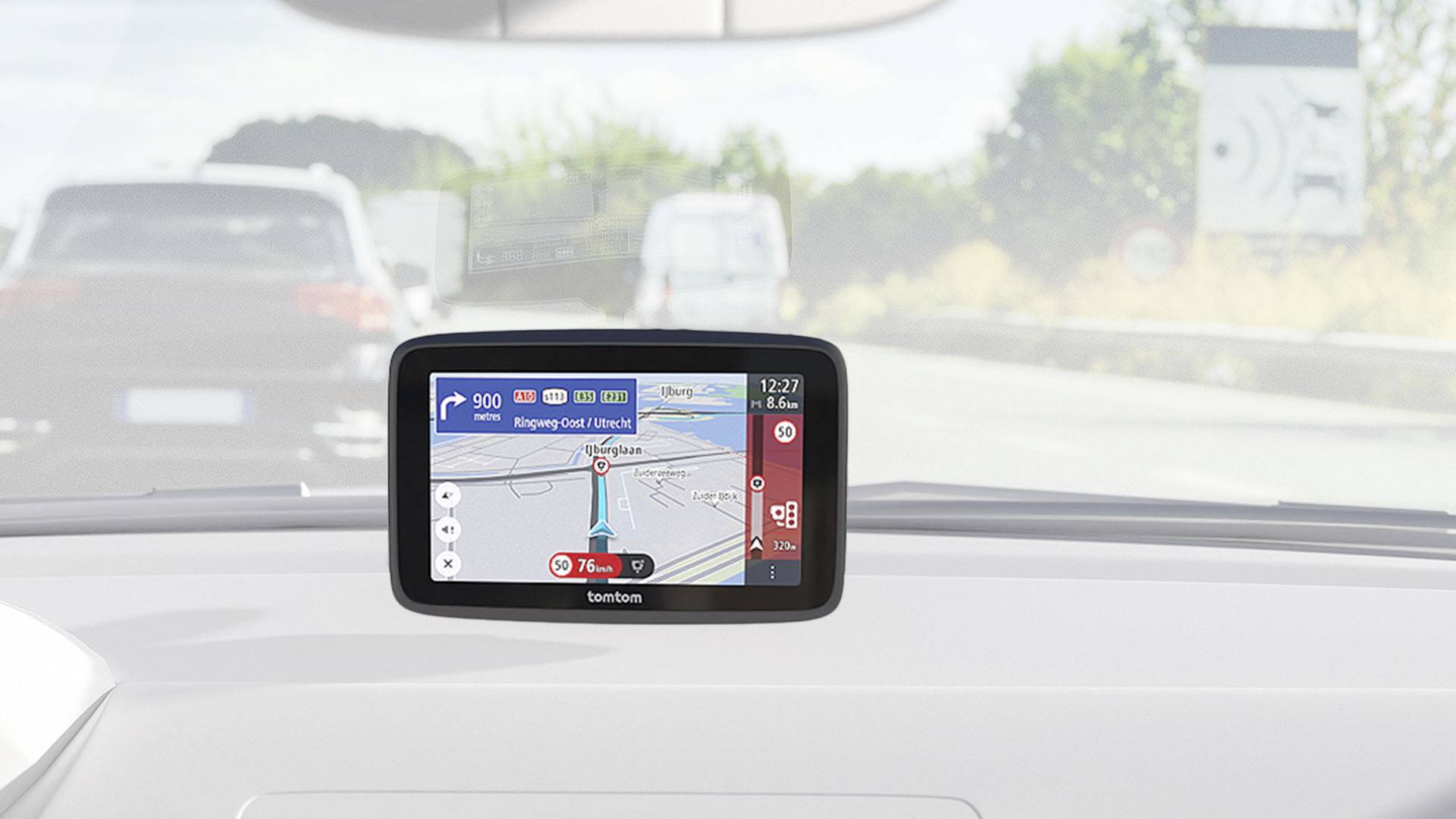 A GPS navigation device in a car displays a road map. The display shows the current route and traffic information.