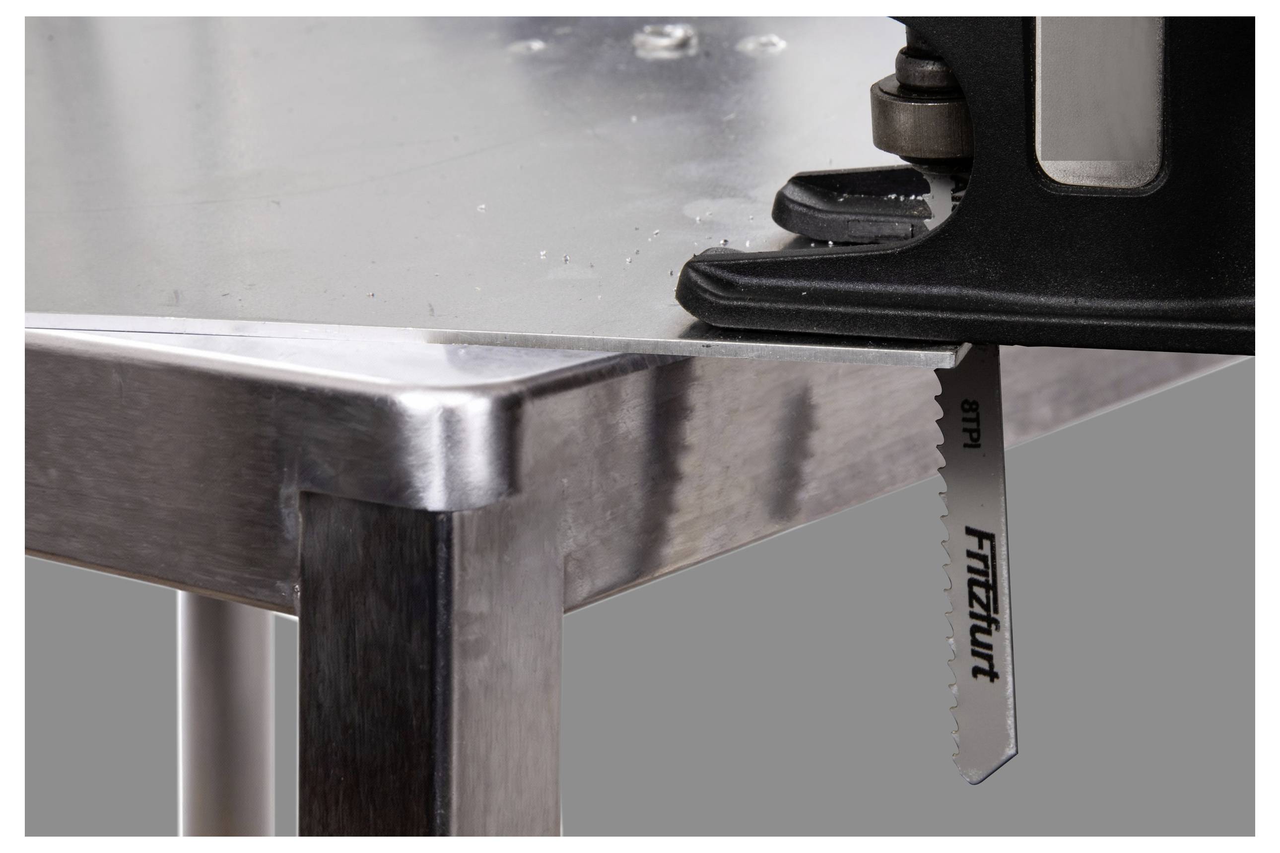 A saw blade protrudes from a metal surface, indicating active cutting or preparation for cutting. The setting appears industrial.
