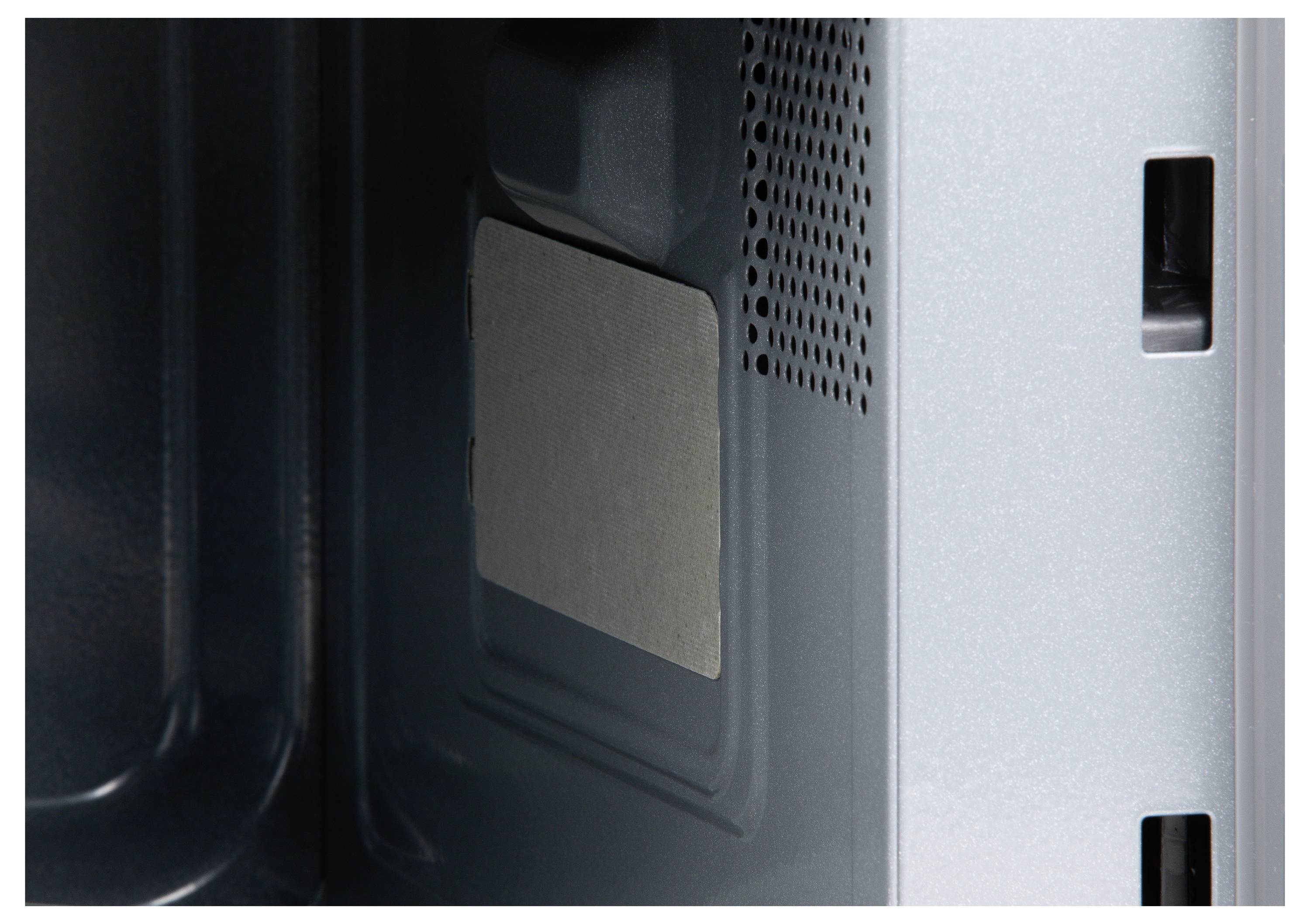 Interior view of a metal enclosure with a rectangular, grey element on the side wall, potentially a protective or insulating panel.