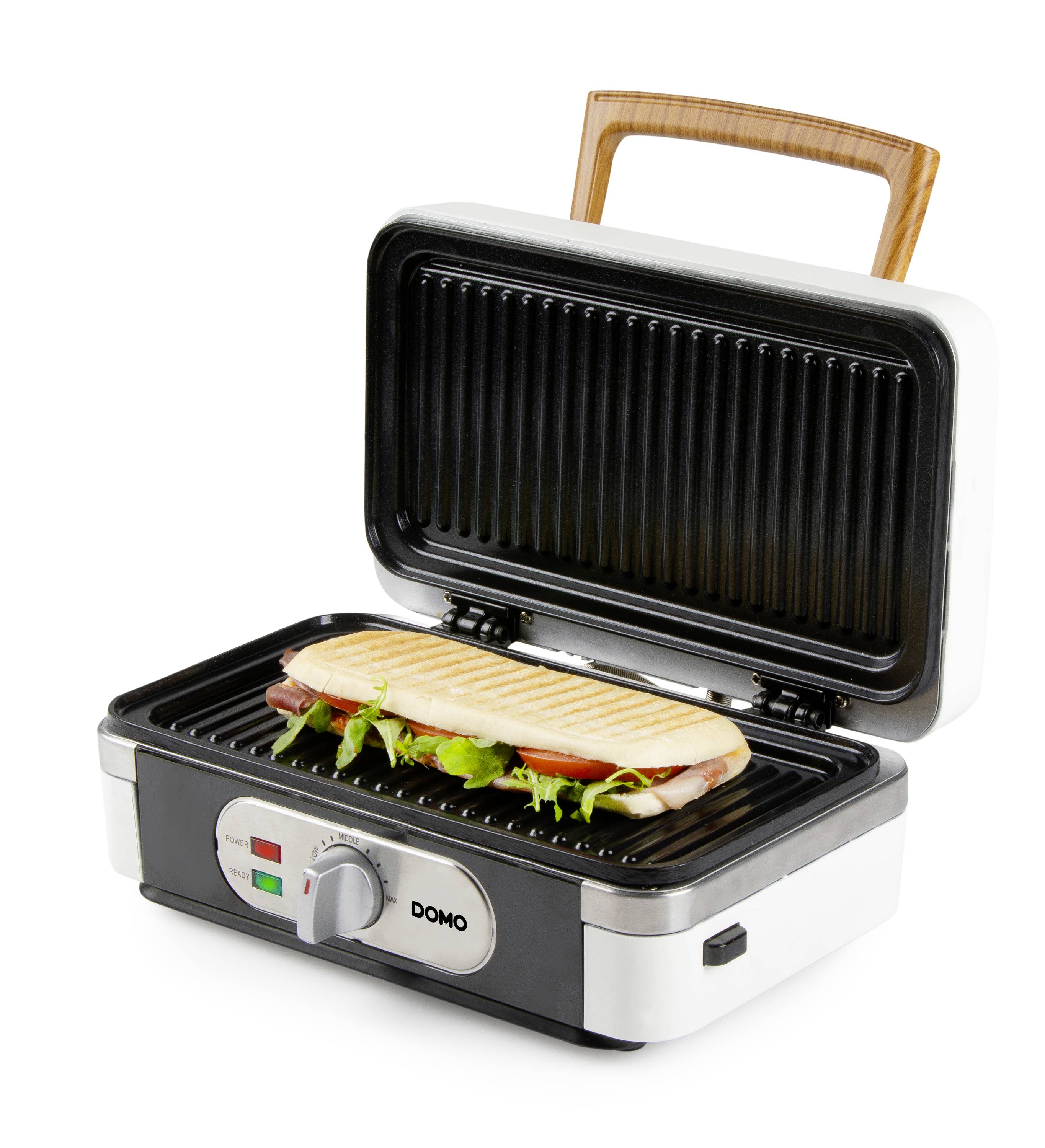 A panini is lying on an open, electrically operated contact grill with a wooden handle, ready to be grilled.