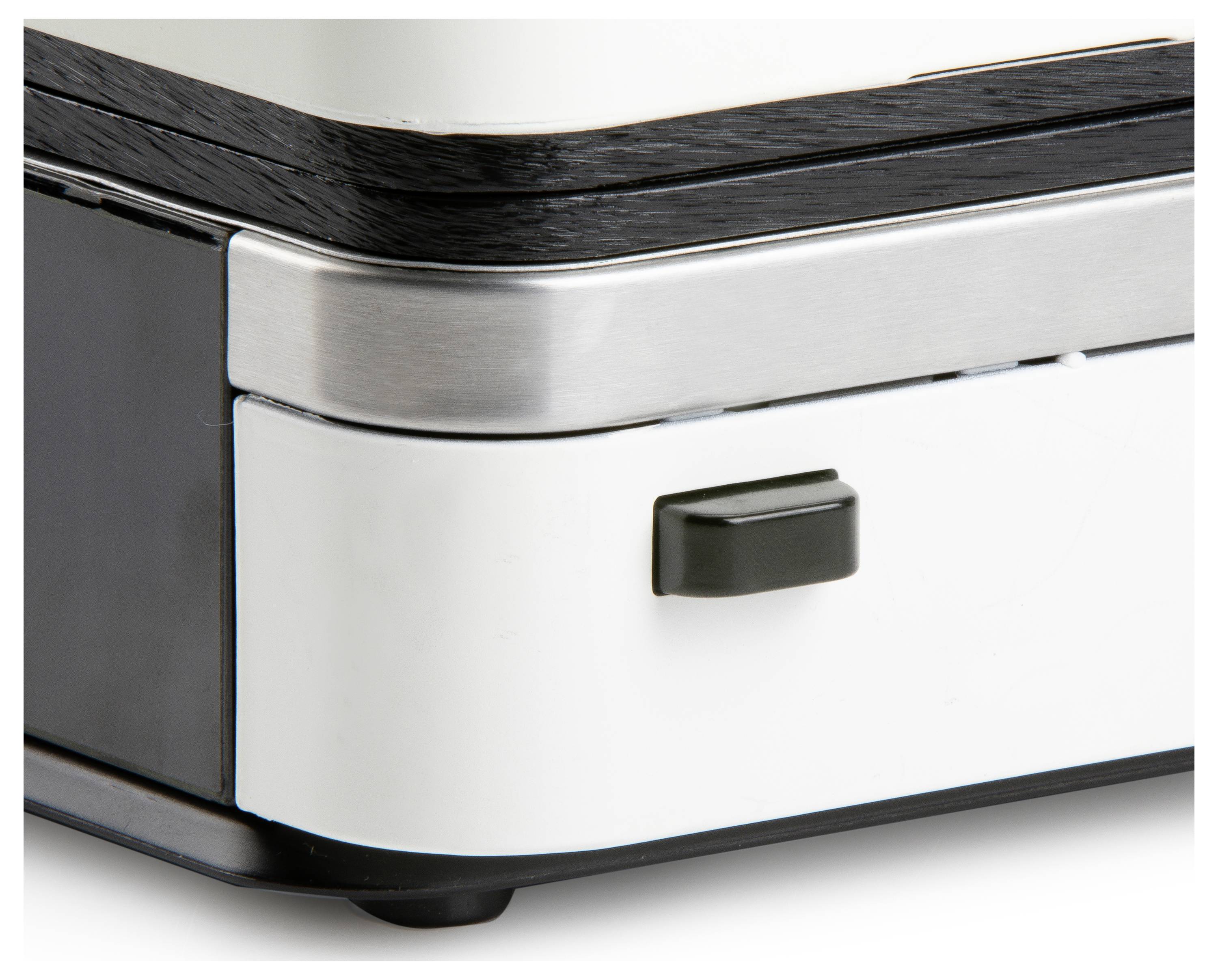 A corner area of a device with metal and plastic elements, a small black button is visible on a white surface.