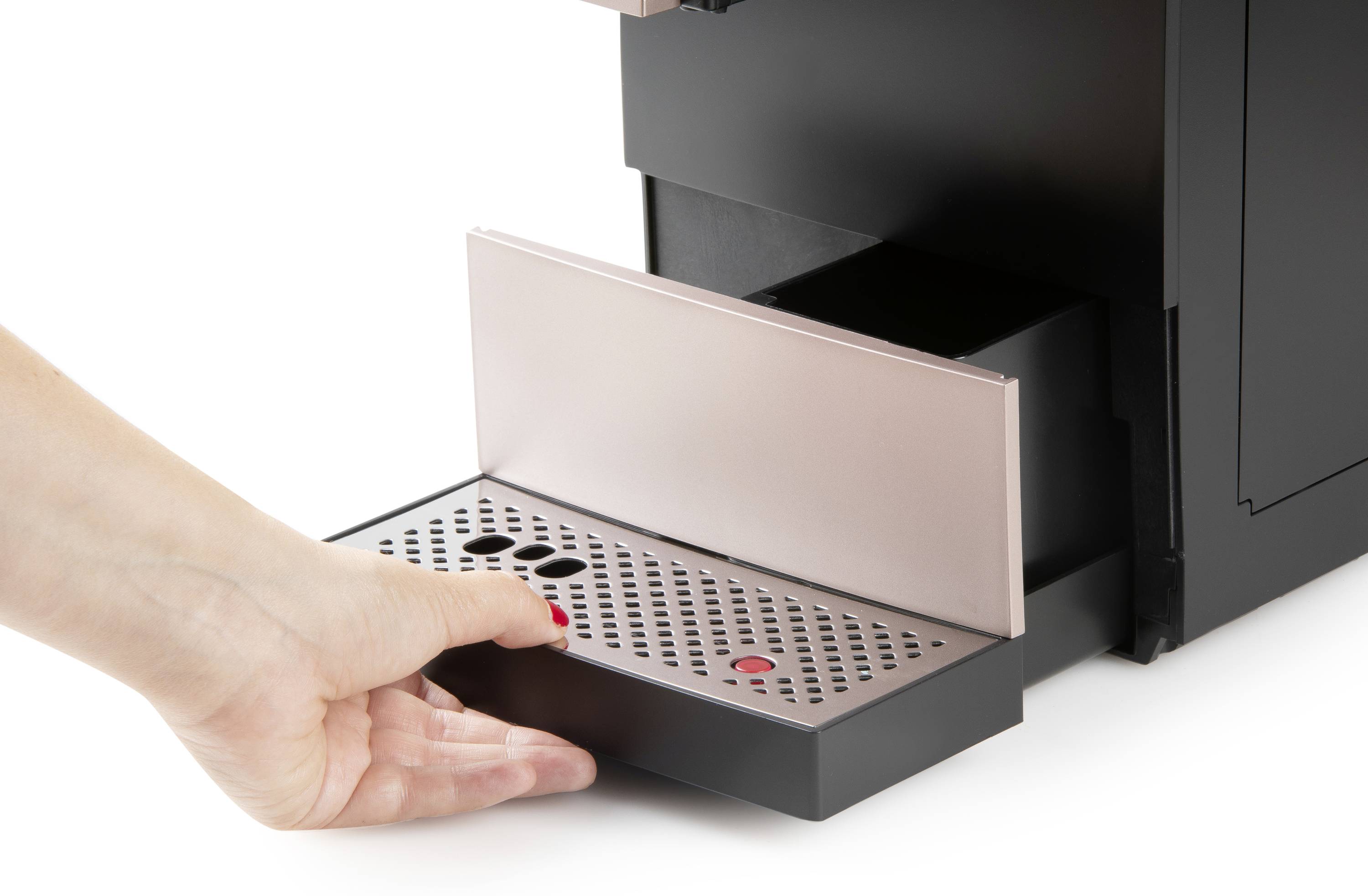 A hand pulls out the drip tray of a coffee machine.