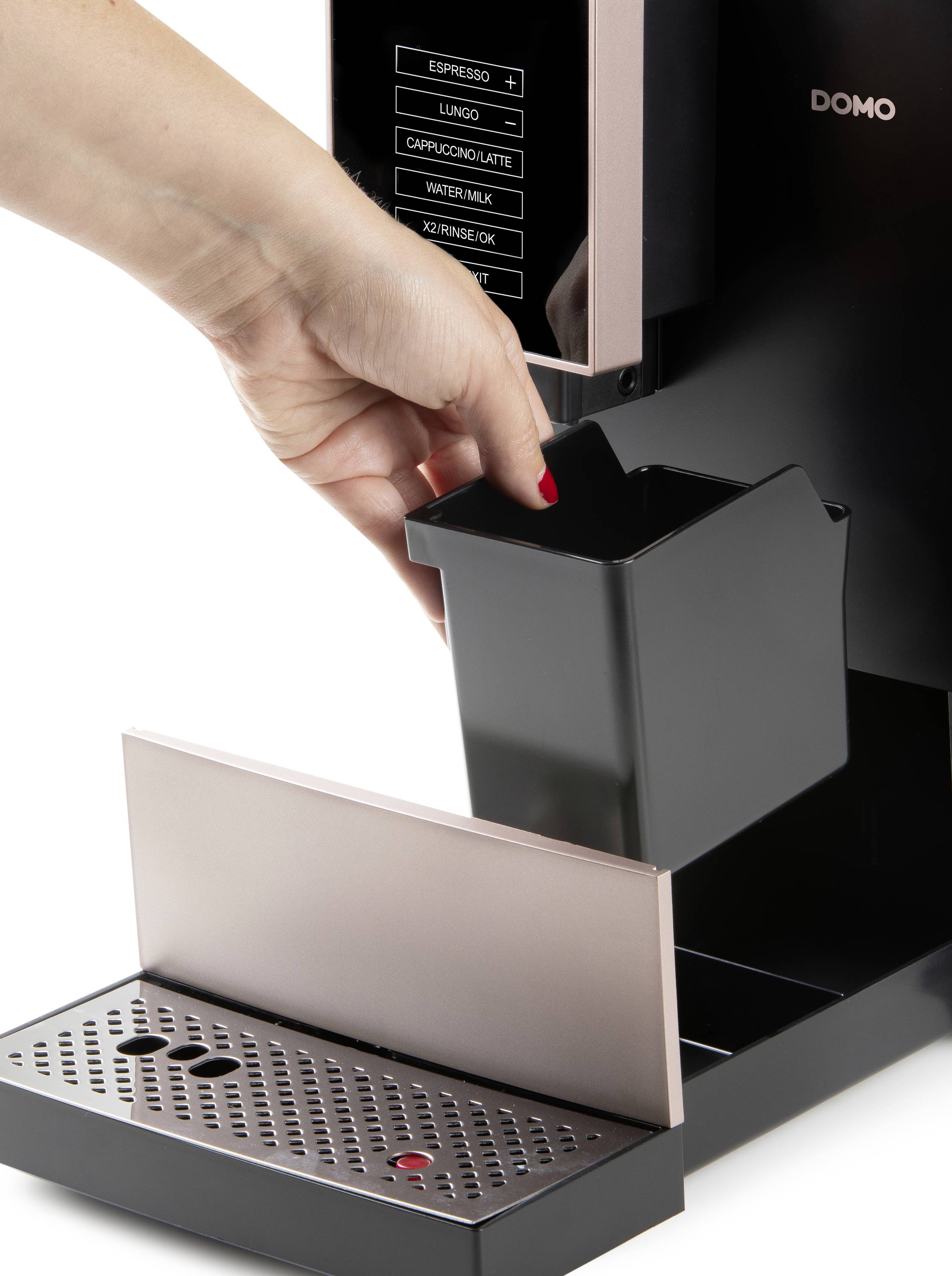 A hand removes the coffee grounds container from a fully automatic coffee machine. Buttons for various coffee options are visible in the top left corner.