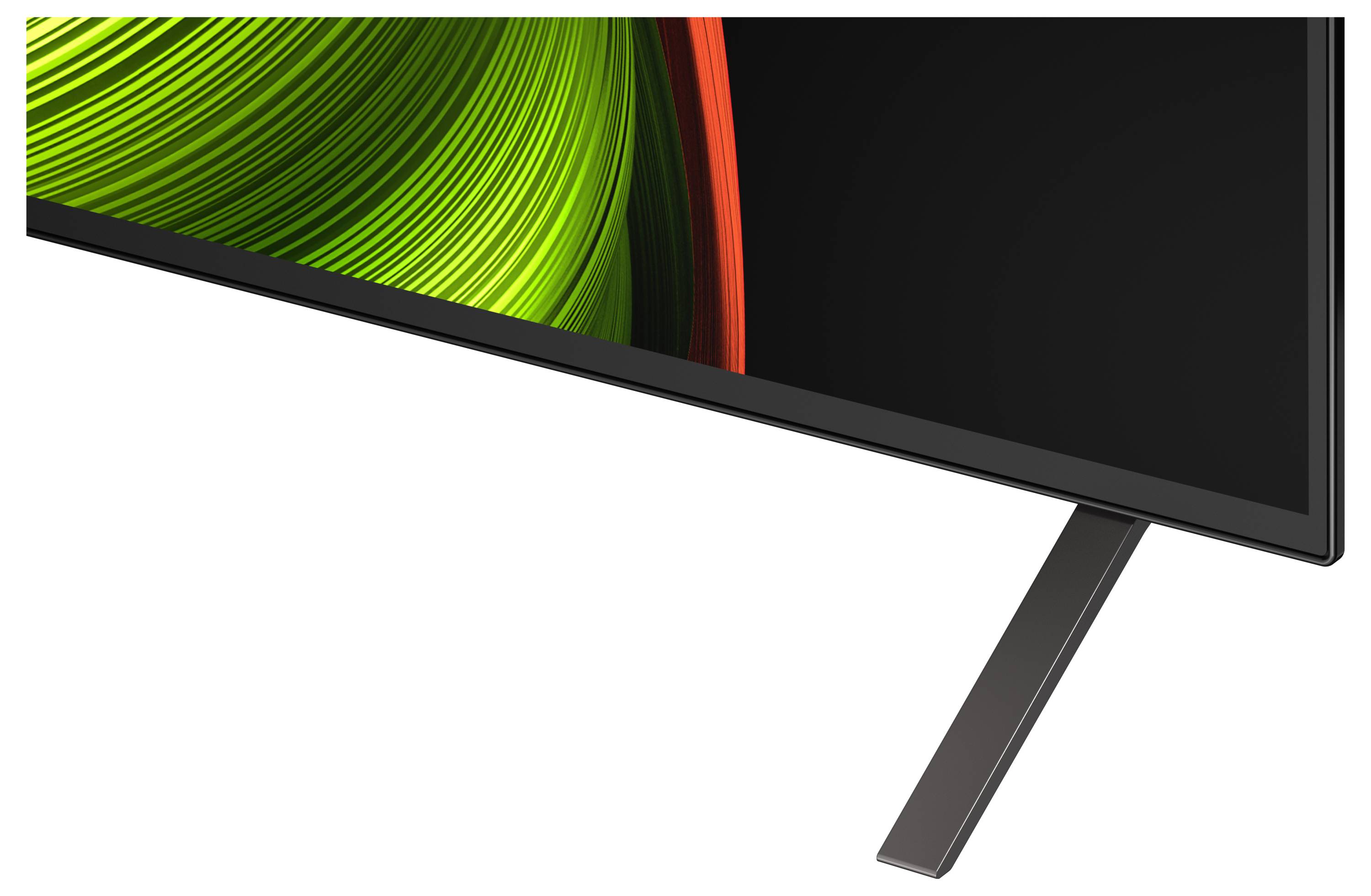 A close-up of a modern television's bottom corner, showing a metallic stand and a portion of the screen displaying abstract green patterns.