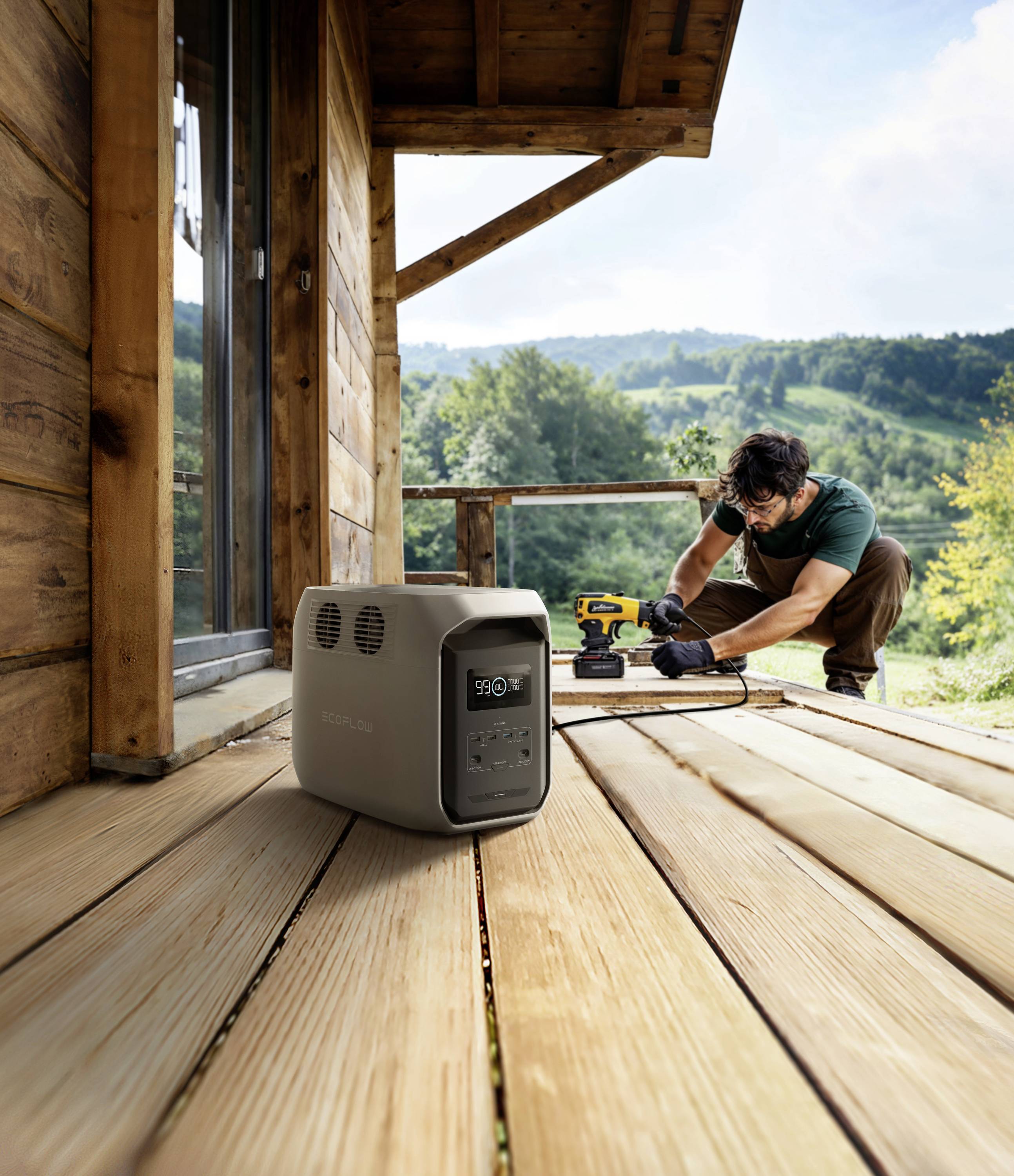 A man is working with tools on a wooden veranda in a natural setting. In the foreground, a portable power generator stands ready to provide electricity.