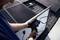 A person is measuring the performance of solar panels on a roof with an electronic device.