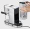 Espresso machine with a removable water tank. Hand removing tank, demonstrating easy handling.